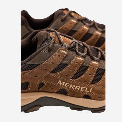 Close-up of a Merrell hiking shoe in brown and black, showing the side profile with the Merrell logo on a light gray background.