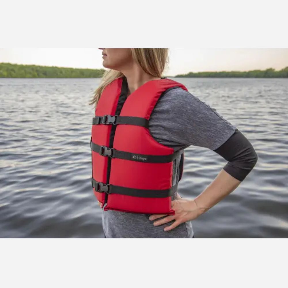 Person wearing a red life jacket on a body of water