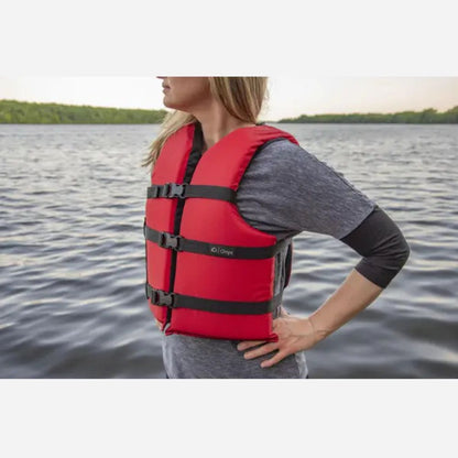 Person wearing a red life jacket on a body of water