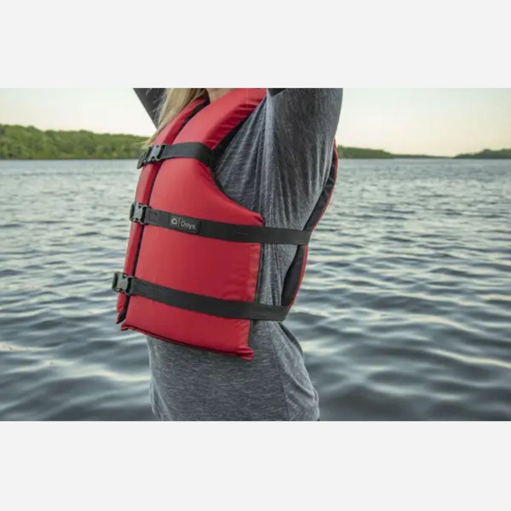 Person wearing a red life jacket on a body of water
