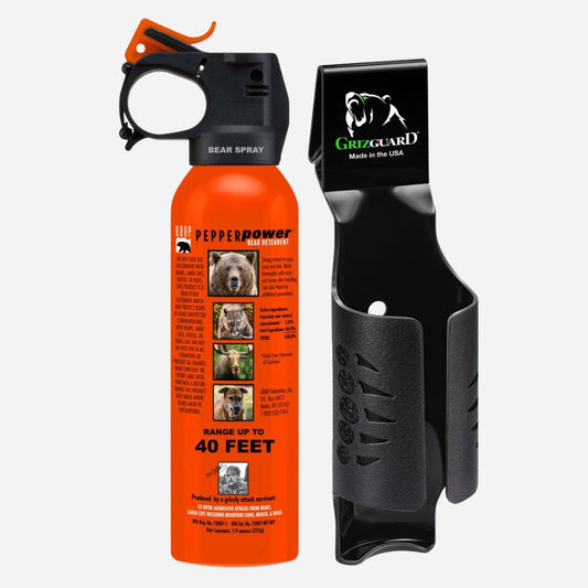Orange bear spray canister with black holder on a white background