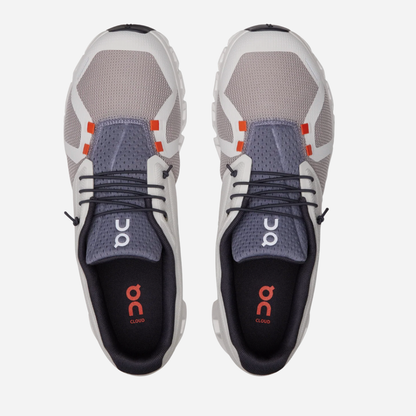 Pair of gray and white athletic shoes with orange accents on a white background